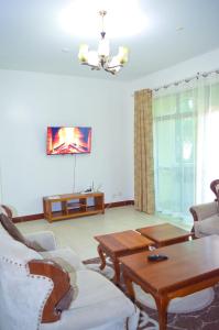 Roma Stays - Cozy 3 Bedroom Apartment with Swimming Pool in Shanzu في مومباسا: غرفة معيشة بها أريكة وطاولة