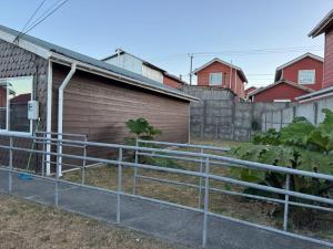 a fence in front of a building with houses at Casa independiente muy acogedora in Puerto Varas