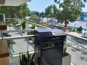 a grill on a balcony with a view of a park at Paseo Victorica - Vista al Río in Tigre