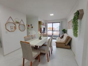 a dining room with a table and chairs and a couch at Lindo Apartamento em Intermares - 03 quartos, todos com ar-condicionado in Cabedelo