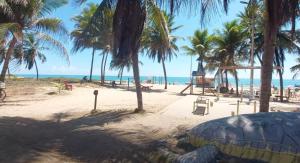 a sandy beach with palm trees and the ocean at Lindo Apartamento em Intermares - 03 quartos, todos com ar-condicionado in Cabedelo