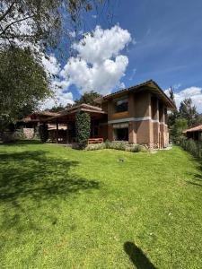 a house with a green lawn in front of it at Luxury house in Urubamba, Cusco, Perú in Urubamba