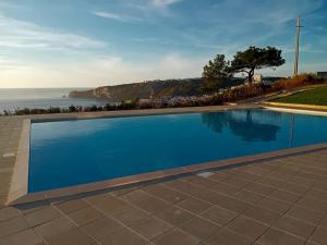 a swimming pool with a view of the ocean at Afrodite Styling Penthouse in Nazaré