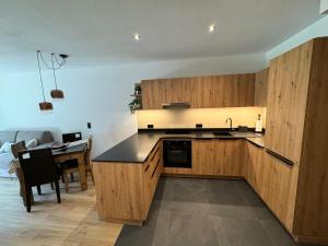 a kitchen with wooden cabinets and a dining room at Renesmee Apartment in Naturno