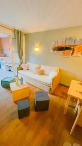 - un salon avec un canapé blanc et des tables dans l'établissement Cap Esterel/Cœur Village/RDJ, à Saint-Raphaël