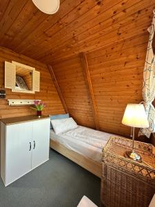 a bedroom with a bed in a wooden cabin at Ferienhaus Seemöwe in Damp