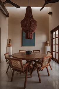 un tavolo da pranzo con sedie e un grande lampadario a braccio di Casa La Piedra a Mérida