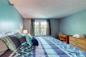 a bedroom with a bed and a desk and a window at Footbridge Escape in Ogunquit