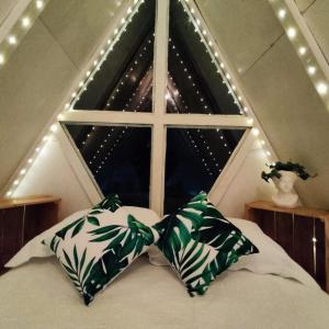 a bed with two pillows in front of a window at Chalet el cerezo in Rionegro