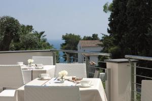 a white table topped with white chairs next to a patio at Relais Paradiso in Vietri sul Mare