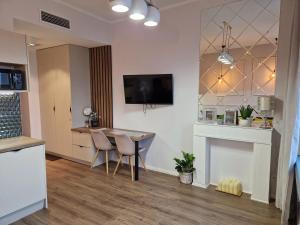 a living room with a table and chairs and a tv at Polonia Apartments in Łódź +12 photos