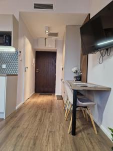 a living room with a table and chairs and a door at Polonia Apartments in Łódź