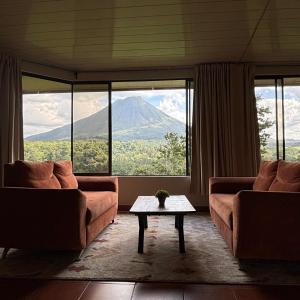 a living room with a view of a mountain at Arenal Roca Lodge & Bungalows in Fortuna