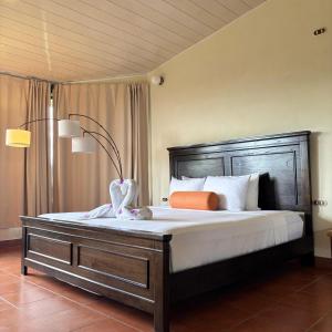 a bedroom with a large bed with a wooden headboard at Arenal Roca Lodge & Bungalows in Fortuna +41 photos