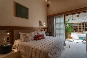 una camera da letto con un letto e una grande finestra di Casa La Piedra a Mérida