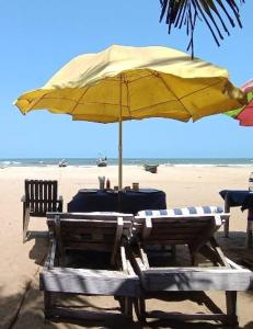 una mesa con una sombrilla amarilla en la playa en Madrid Home 2 min walk to Beach, en Arambol