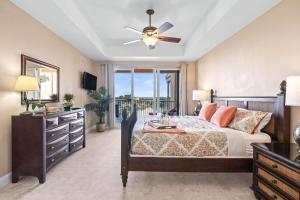 a bedroom with a bed and a ceiling fan at Waterfront Breeze Condo in Clearwater Beach +36 photos