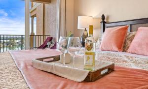 a bottle of wine and a glass on a bed at Waterfront Breeze Condo in Clearwater Beach
