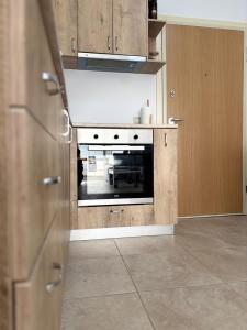 a kitchen with an oven and wooden cabinets at Qerret Sands Apartment in Golem