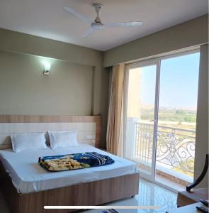 a bedroom with a bed and a large window at Eraya Elegance Inn in Chhatikara