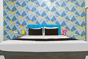 印多尔FabHotel Paradise Inn的一间卧室配有一张蓝色和黄色墙壁的床 更多24张照片