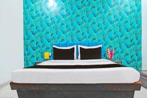 印多尔FabHotel Paradise Inn的卧室里有一张床，墙壁是蓝色的