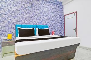 印多尔FabHotel Paradise Inn的蓝色墙壁间的一张床位