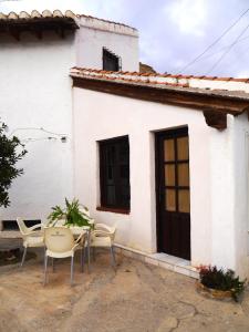 a white house with a table and chairs in front of it at La Casita de Sandra in Paulenca