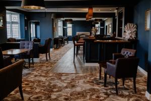 伯克利The Prince of Wales Hotel Berkeley, A38 M5的餐厅拥有蓝色的墙壁和桌椅