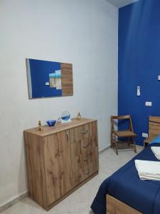 a bedroom with a bed and a wooden cabinet at Casa Roxy in Trapani