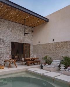 un patio con piscina, tavolo e sedie di Casa La Piedra a Mérida