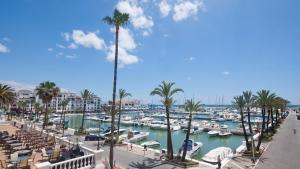 a marina with boats in the water and palm trees at Duquesa Marina - Manilva Beach Home in Manilva