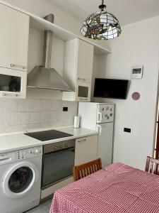 Lady's home في لا سبيتسيا: مطبخ مع موقد وغسالة ملابس