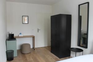 a bedroom with a black cabinet and a desk at Gästehaus Friedrichstraße - Einzelzimmer im Zentrum in Paderborn