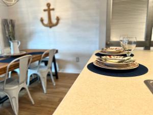 a dining room table with plates and glasses on it at Top Floor Beach Retreat Tennis Courts Views 1812 in Seabrook Island