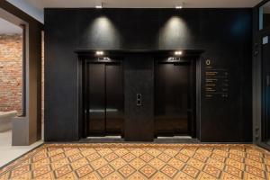 dos puertas negras en un pasillo con una alfombra en Wawel View Stylish Apartment - Kościuszki 22, en Cracovia