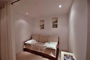 een bed in een kamer met drie foto's aan de muur bij Apartamento Golden View in Cabanas de Tavira +14 foto's