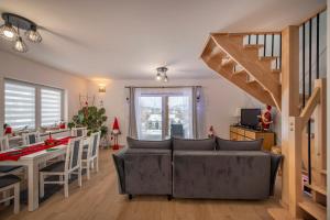 a living room with a couch and a table and a staircase at Dom z Widokiem na Góry i Jacuzzi - "Domki na Słonecznym Wzgórzu" in Lądek-Zdrój