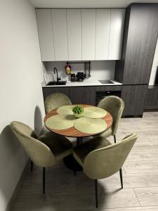 una mesa y sillas en una cocina con mesa en MB Livinga apartamentai Gedimino g, en Mažeikiai