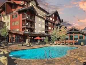 ein Hotel mit einem Swimmingpool vor einem Gebäude in der Unterkunft Studio Purgatory Townhome 104 in Durango Mountain Resort