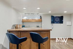 a kitchen with two blue chairs at a bar at Twin Lakes Village 3-Story Townhouse Golf Views Steam Shower Wet Bar Game Room Pool in Rathdrum