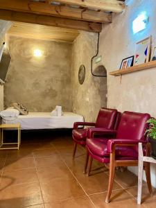タリファにあるCharming Studio with Private Patio in Old Townのベッド1台と赤い椅子2脚が備わる客室です。