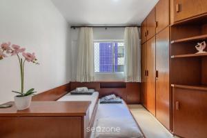 a room with a bed and a desk and a window at Apto 3Q c/ varanda a 100m da Praia em BC EVZ0601 in Balneário Camboriú