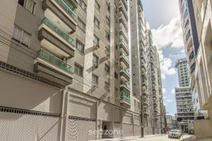 a tall building in the middle of a street at Apto 3Q c/ varanda a 100m da Praia em BC EVZ0601 in Balneário Camboriú