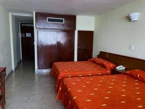 a hotel room with two beds and a door at Hotel Royalty in Veracruz