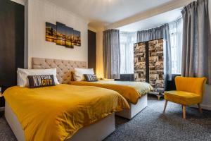 a bedroom with two beds and a yellow chair at Fionn House Darlington in Darlington