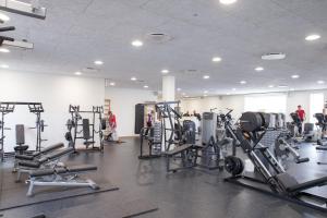 ein Fitnessstudio mit mehreren Laufbändern und Personen im Hintergrund in der Unterkunft Vildbjerg Sports Hotel & Kulturcenter in Vildbjerg