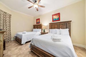 een slaapkamer met twee bedden en een plafondventilator bij The Oasis at Orange Beach 1813 (formerly known as Phoenix West II) in Romar Beach