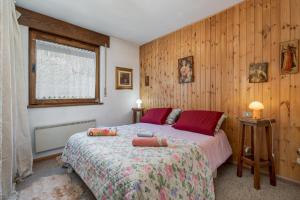 un dormitorio con una cama y una ventana en Appartamento Vittoria, en Cavalese