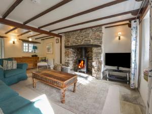 a living room with a fireplace and a couch and a table at 1 Gabberwell Cottages in Kingston